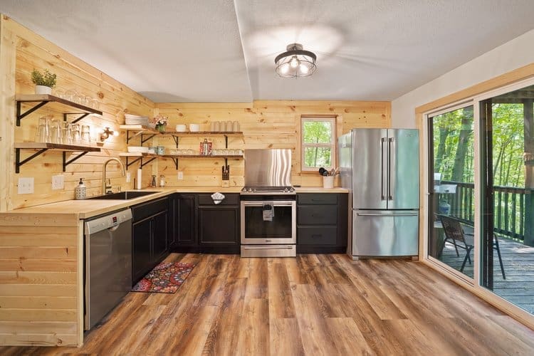 The fully equipped kitchen features an array of stainless steel appliances, including a side-by-side refrigerator, oven, dishwasher, and gas stove to satisfy the chef and all their needs.