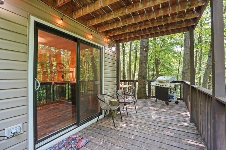 A sprawling wrap around deck, located in the back of the cabin among the trees, not only offers a breathtaking view but a gas grill and seating area.